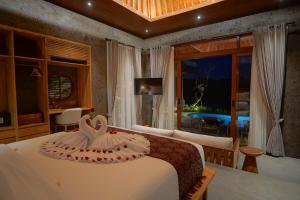 a bedroom with a bed with a dress on it at Ningtaru Villa Ubud in Penginyahan +46 photos