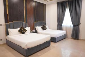 a hotel room with two beds and a window at Envoy Express, Islamabad in Islamabad