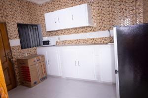 Una cocina con gabinetes blancos y una caja en una habitación. en Logement entier appartement Mariste, en Hann 28 fotos más