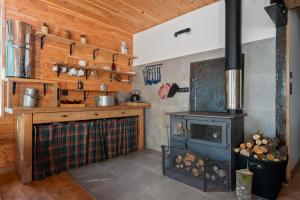 a kitchen with a woodburning stove and a stove at Se Ressourcer En Forêt in Yzeron