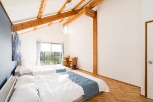 una camera da letto con due letti e una finestra di Echoes of Forest エコーズオブフォレスト 森の音が聴こえるロッジ a Minamioguni