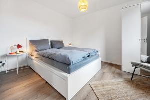 ヘンミンゲンにあるUnterkunft für Messen und Freizeitの白いベッドルーム(青いシーツ付きのベッド1台付)