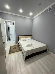 a bedroom with a bed with two towels on it at Новая уютная комфортная квартира с современным ремонтом in Astana