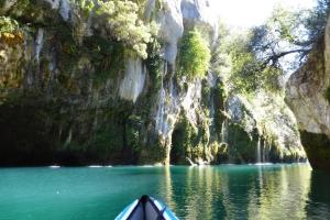 a boat in the water next to a rocky mountain at Charmant T2 150 m de la cure thermale Gorges Du Verdon in Gréoux-les-Bains