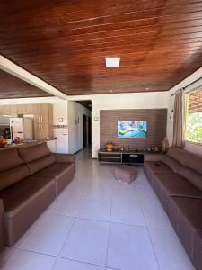 ein Wohnzimmer mit zwei braunen Sofas und einem Flachbildfernseher in der Unterkunft Experiência surreal em Àguas de Olivença, Ilhéus BA in Olivença