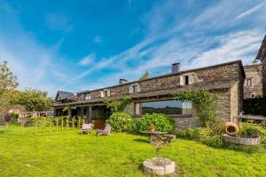 an old stone house with a yard at As Casias d'Oscos in Villanueva de Oscos