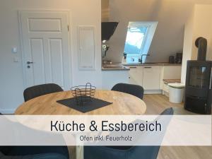 a kitchen and dining room with a wooden table in a room at Meine Schule Sehlingen, Familien & Generations Landurlaub, Freunde & Team-Auszeit, Workation, Sauna, Ruhe & Erholung, Niedersachsen, Verden, Hamburg, Bremen, Lüneburger Heide, Heide Park 38 km , Serengeti Park 39 km, Weltvogelpark 22 km in Kirchlinteln