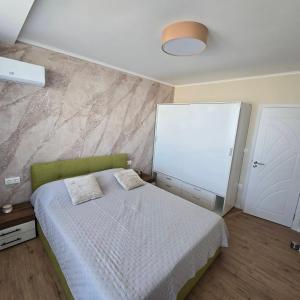 Un dormitorio con una cama y una pared. en Апартамент Пловдив, en Plovdiv