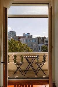 a balcony with a table and a view of a city at Huswell - New Penthouse with City & Harbour Views in Ostend +28 photos