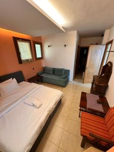 a bedroom with a large bed and a couch at RASTONI Pelion in Vizitsa