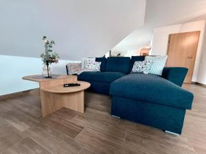 a living room with a blue couch and a table at sleepWELL-Metelen - Ausblick & Sehr Modern in Metelen