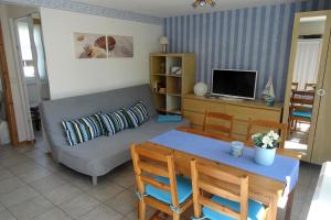 Bungalow Möwe im Ostseeidyll am Waldrand في أوستسيباد نينهاجن: غرفة معيشة بها أريكة وطاولة