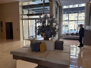a man walking in a lobby with a large couch at Pavilion Hotel Al Jaddaf in Dubai