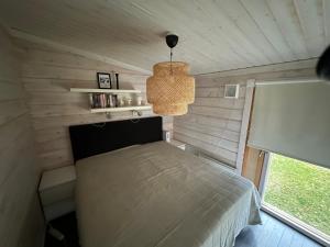 ein Schlafzimmer mit einem Bett in einem Zimmer mit einem Fenster in der Unterkunft Lapland Lakefront Villa - Northern Lights & Safari in Ranua