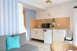 Bungalow Krabbe im Ostseeidyll am Waldrand في أوستسيباد نينهاجن: غرفة معيشة مع مطبخ مع أريكة وميكرويف