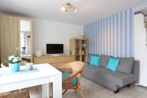 Bungalow Krabbe im Ostseeidyll am Waldrand في أوستسيباد نينهاجن: غرفة معيشة بها أريكة وطاولة