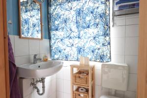 Bungalow Krabbe im Ostseeidyll am Waldrand في أوستسيباد نينهاجن: حمام مع حوض وستارة دش زرقاء وبيضاء