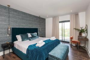 Un dormitorio con una cama grande con toallas. en Blooms House - Cookswood, en Holcombe