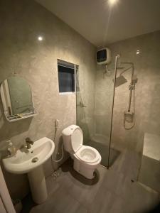 Un baño con ducha, inodoro y lavabo. en Residence 22, en Mama