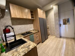 una cocina con fregadero y refrigerador en Residence 22, en Mama