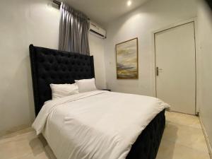 Un dormitorio con una cama grande con cabecero negro. en Residence 22, en Mama