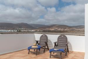 2 Stühle auf einem Balkon mit Bergen im Hintergrund in der Unterkunft La Casita Villalba in Arrieta