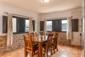 ein Esszimmer mit einem Holztisch und Stühlen in der Unterkunft La Casita Villalba in Arrieta