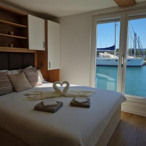 a bedroom with a bed with two swans on it at Luxury Floating Sea House Star Line - Marina Portorož in Portorož