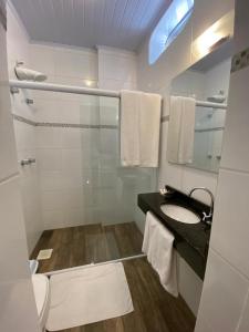 a bathroom with a sink and a mirror at Pousada Natália in Torres +56 photos
