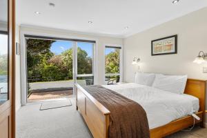 a bedroom with a bed and a large window at Ngati Ruanui Mountain Lodge in Stratford