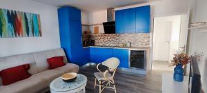a living room with a couch and a kitchen with blue cabinets at Apartmany Tisno Nikola in Tisno +9 photos