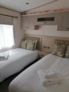a bedroom with two beds with towels on them at Elmvale - 2 bedrooms with decking sleeps 4 in Hastings
