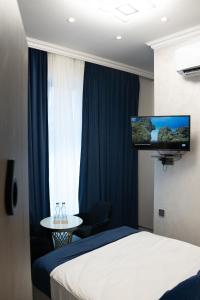 a hotel room with a bed and a tv on the wall at Prime Suites Hotel in Yerevan