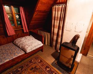 a small bedroom with a bed and a small stove at Almhütte am Seeberg in Brandhof +8 photos
