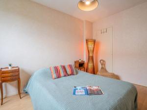 a bedroom with a bed with two books on it at Apartment Demeures de Maignon by Interhome in Anglet