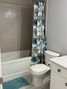 a bathroom with a toilet and a shower curtain at one bet room in Whitby