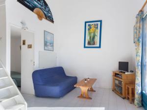 sala de estar con silla azul y mesa en Holiday Home Le Domaine d'Azur-1 by Interhome, en Le Lavandou