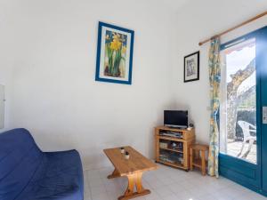 Una sala de estar con un sofá azul y una mesa. en Holiday Home Le Domaine d'Azur-1 by Interhome, en Le Lavandou