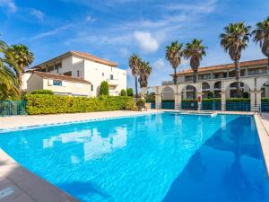Una gran piscina azul frente a un edificio en Holiday Home Le Domaine d'Azur-1 by Interhome, en Le Lavandou