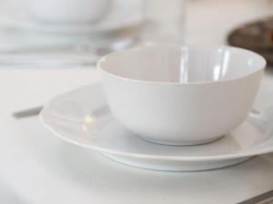 a white bowl on a plate on a table at Apartment Chesa Prasüra 10 by Interhome in Sils Maria +24 photos