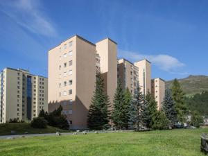 a large building with a grass field in front of it at Apartment Chesa Ova Cotschna 306 by Interhome in St. Moritz