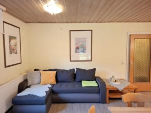 大格洛克纳山道旁富施Holiday Home Bergfried by Interhome的客厅里有一张蓝色的沙发和一张桌子 更多66张照片