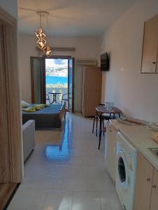 a kitchen and living room with a view of the ocean at Akrogiali Rooms & Studios in Drymonas