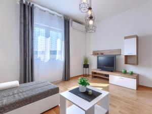 a living room with a couch and a tv at Apartment Katarina-1 by Interhome in Rabac