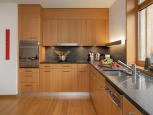 a kitchen with wooden cabinets and stainless steel appliances at Apartment Residenz Cresta Kulm B26 by Interhome in Celerina +47 photos