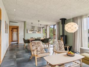 a living room with a table and chairs at Holiday Home Eila - 400m from the sea by Interhome in Glesborg +15 photos