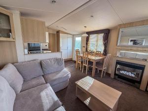 a living room with a couch and a table at Lovely Caravan With Spacious Decking At North Denes In Suffolk, Ref 40134Nd in Lowestoft