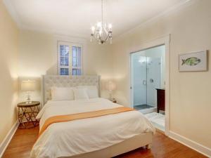 a bedroom with a large bed and a chandelier at Liberty Street Retreat in Savannah +22 photos