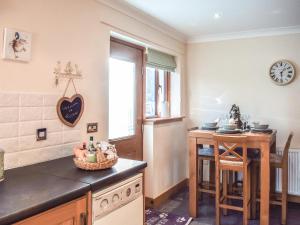 una cocina con una mesa y una encimera en Trelaw - Uk41532, en Ochiltree 17 fotos más