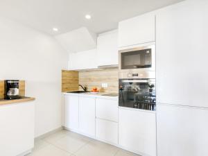 a kitchen with white cabinets and a refrigerator at Apartment Mileni I by Interhome in Roses